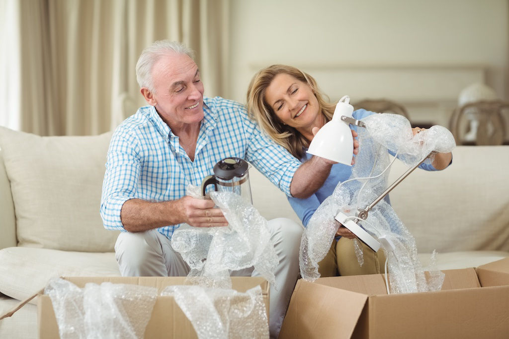 Senior couple unpacking box at apartment